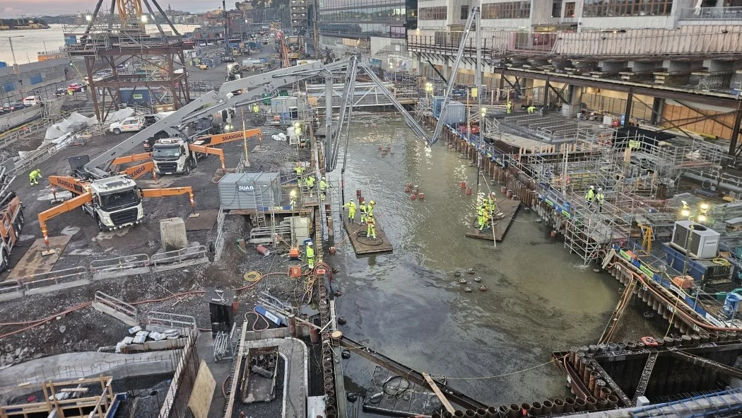 Stor hamnbyggarbetsplats under lång betonggjutning med flera arbetslag och pumpar